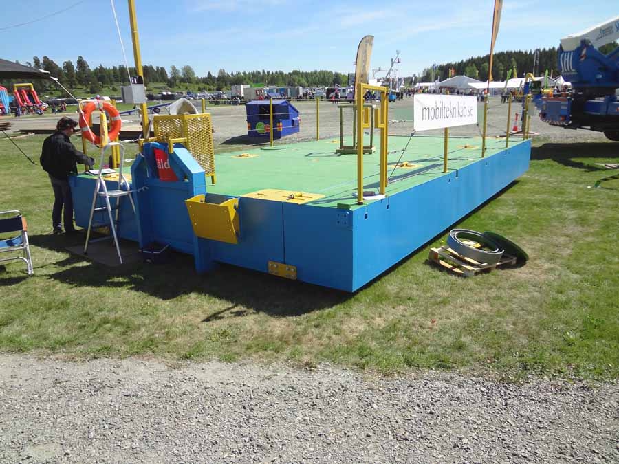 Tämä koukkulava-autolla siirrettävissä oleva työlautta oli varsin kätevän tuntuinen keksintö. Lautan molemmat sivut ovat käännettävissä keskiosan päälle, jolloin kokonaisleveys mahdollistaa tavanomaisen maantiekuljetuksen.