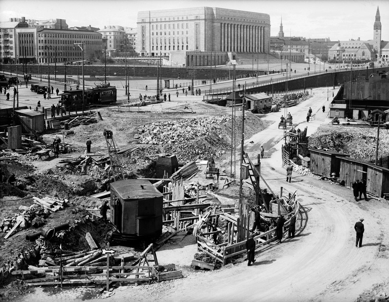 Heikinkatu. Mannerheimintie, sama katutyö kuin edellisessä kuvassa, moottorikäyttöinen tela-alustainen nosturi on varmaan sama kone kuin edellisessä kuvassa, ristikkopuominostureita käytettiin syvien kanaalien kaivamiseen siten, että kaivumassat nostettiin jassikalla kaivannosta ylös, vuosi 1935, Foto Roos, Helsingin kaupunginmuseo