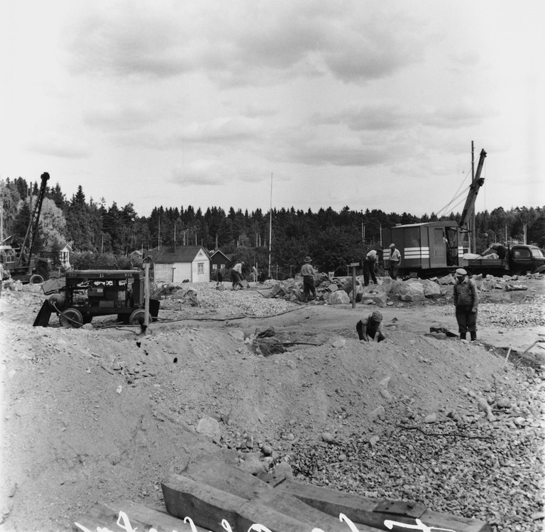 Sama työmaa, kaivukoneessa on tavallinen peruspuomi, jonka päähän on lisätty toista metriä pitkä jatkos, jotta koneella voisi paremmin tehdä nostotöitä, kuva: Okkola Bertel, Helsingin kaupunginmuseo.