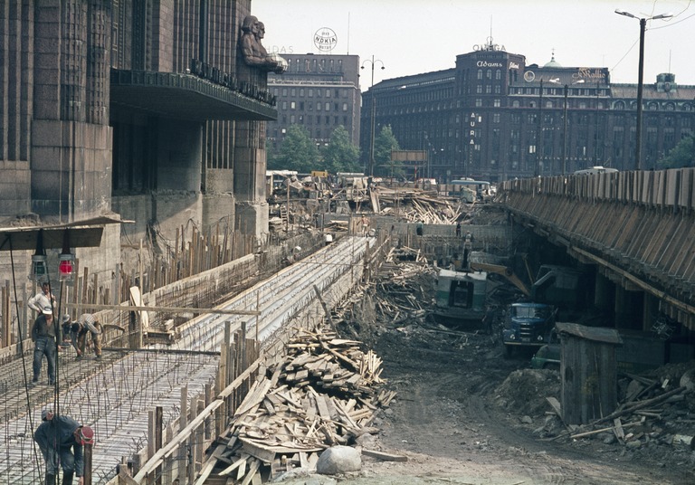Tunnelityömaa on edennyt hieman pidemmälle, kuopassa näkyy nyt kaksi Lokomoa, edellisessä kuvassa olevan kompressorin ja kaivinkoneiden väristä päätellen urakoitsija on Maa ja kallio, kuva Grünberg Constantin, Helsingin kaupunginmuseo.