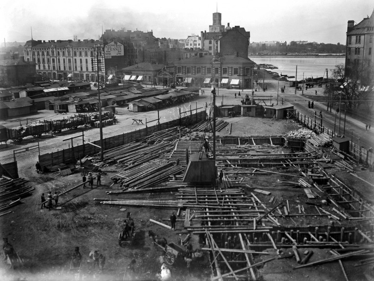 Hakaniemen hallin rakennustyömaa 1912-1914, perustuksen puupaaluja lyödään höyrykäyttöisellä juntalla, kuva Helsingin kaupunginmuseo.