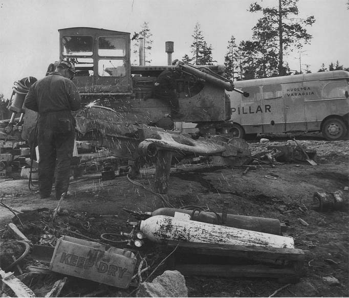 Caterpillar palasina kankaalla ja piirihuoltomies Vainio työssään 60-luvulla.